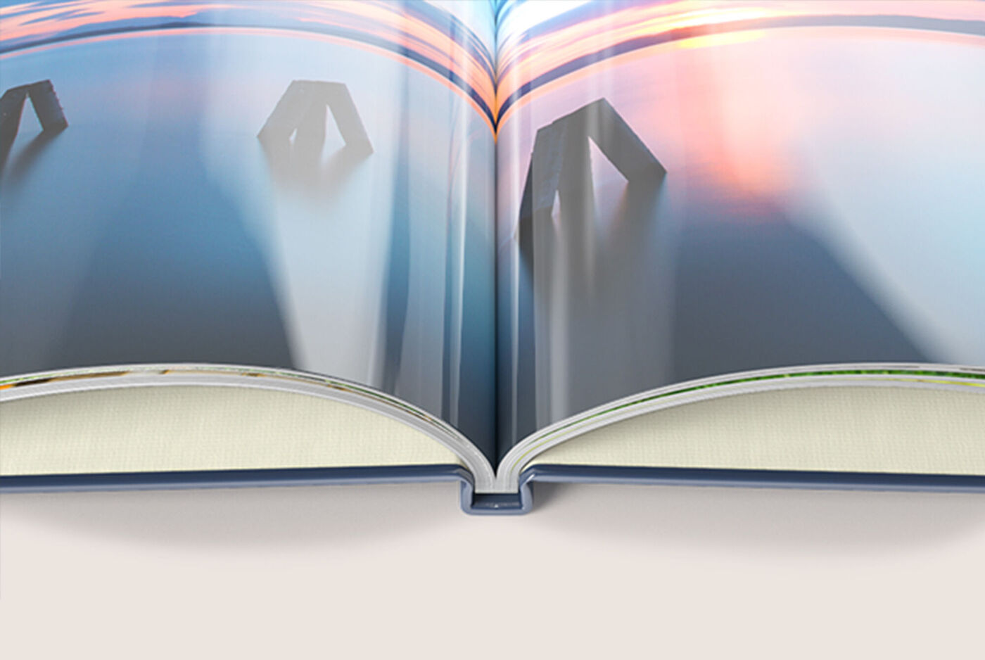Offenes CEWE FOTOBUCH mit sanften Farben und einem verträumten Sonnenuntergang im Hintergrund