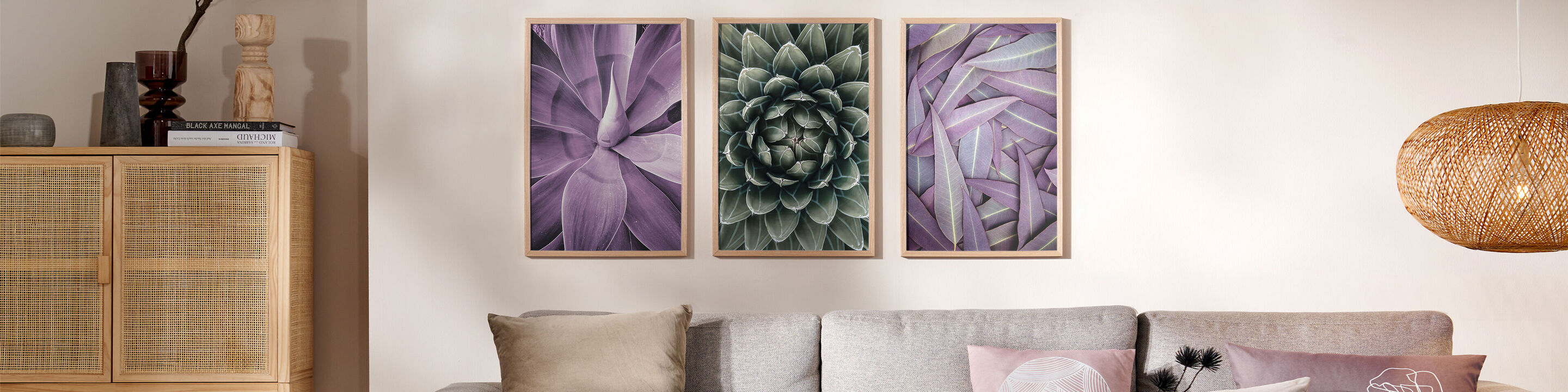 Drei Bilder von Pflanzen mit lila Farben hängen an einer Wand über einem Sofa