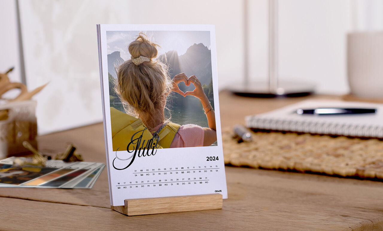 Kostenloser Tischkalender für den Monat Juni, 2025, mit einem liebevoll gestalteten Foto einer Person, die ein Herz aus Händen formt.