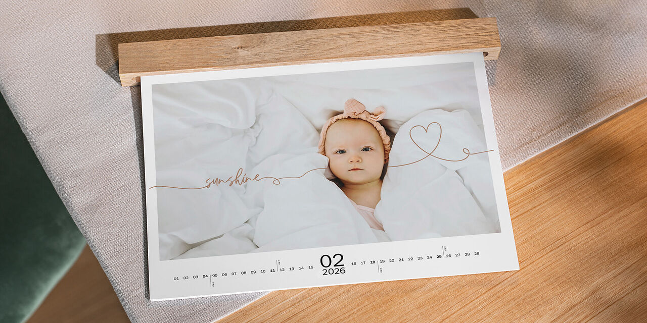 Ein niedlicher Fotokalender zeigt ein Baby in einer gemütlichen Decke und einen sanften Monat mit 02 2024.