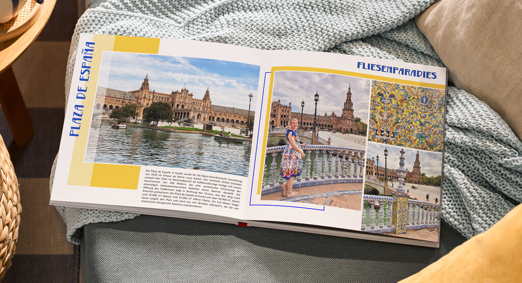 Auf einem Sofa liegt ein aufgeschlagenes Fotobuch. Die Fotos zeigen Gebäude und Fliesenmuster aus Andalusien.