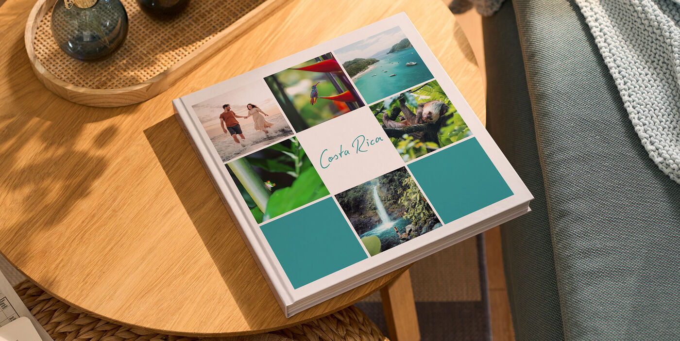CEWE FOTOBUCH auf einem Tisch mit Costa-Rica-Titel und kleinen Urlaubsfotos auf dem Cover
