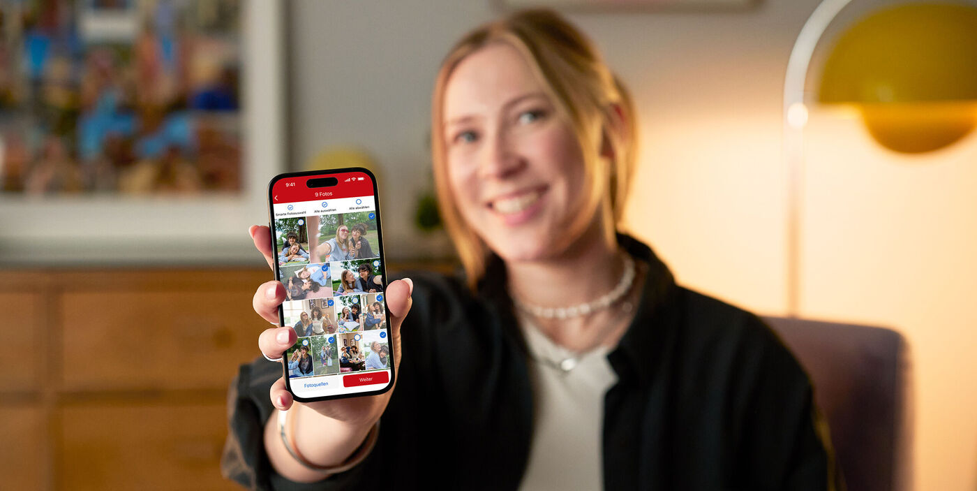 Eine Person hält ein Smartphone mit Bildern von Freunden und Familie in der Galerie.