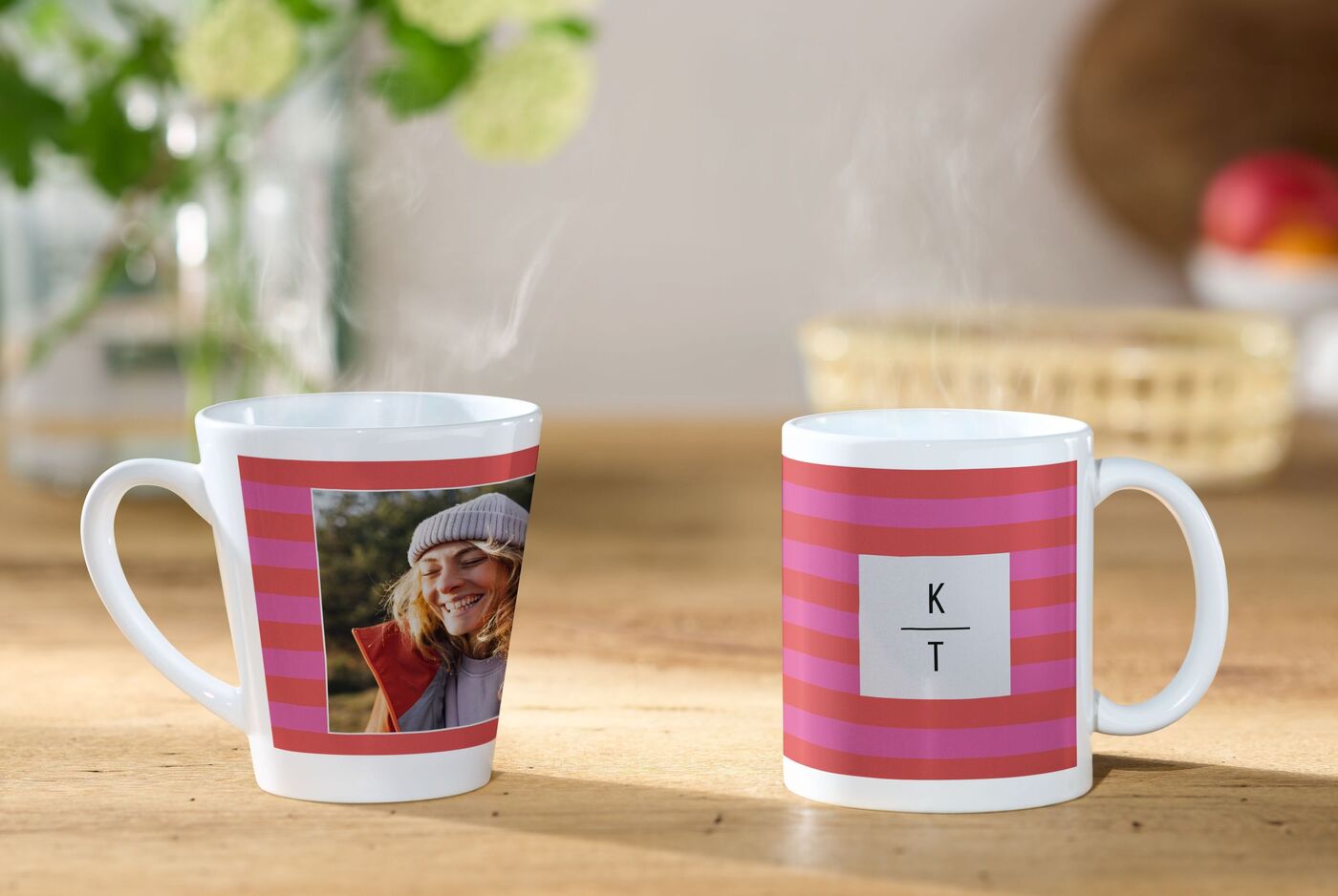 Zwei individuell gestaltete Tassen mit Fotos und Initialen, auf einem Holztisch.