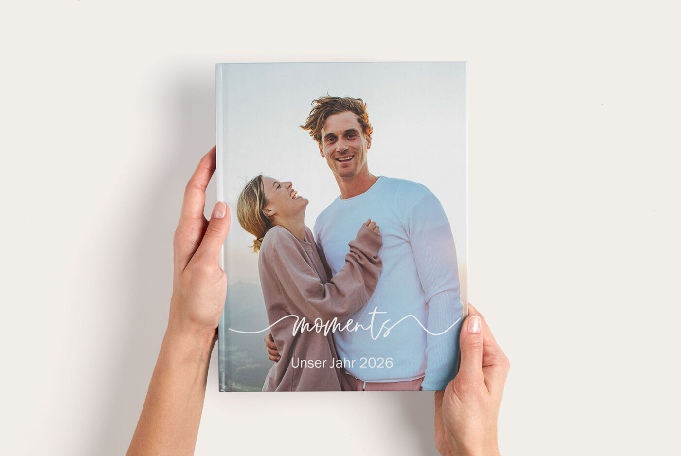 CEWE FOTOBUCH mit minimalistischem Cover in sanften Farben, dem Schriftzug „moments“