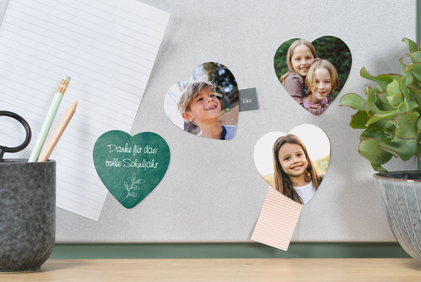 Herzförmige Notizen mit kleinen Fotos und Dankesnotiz auf einer Wand.