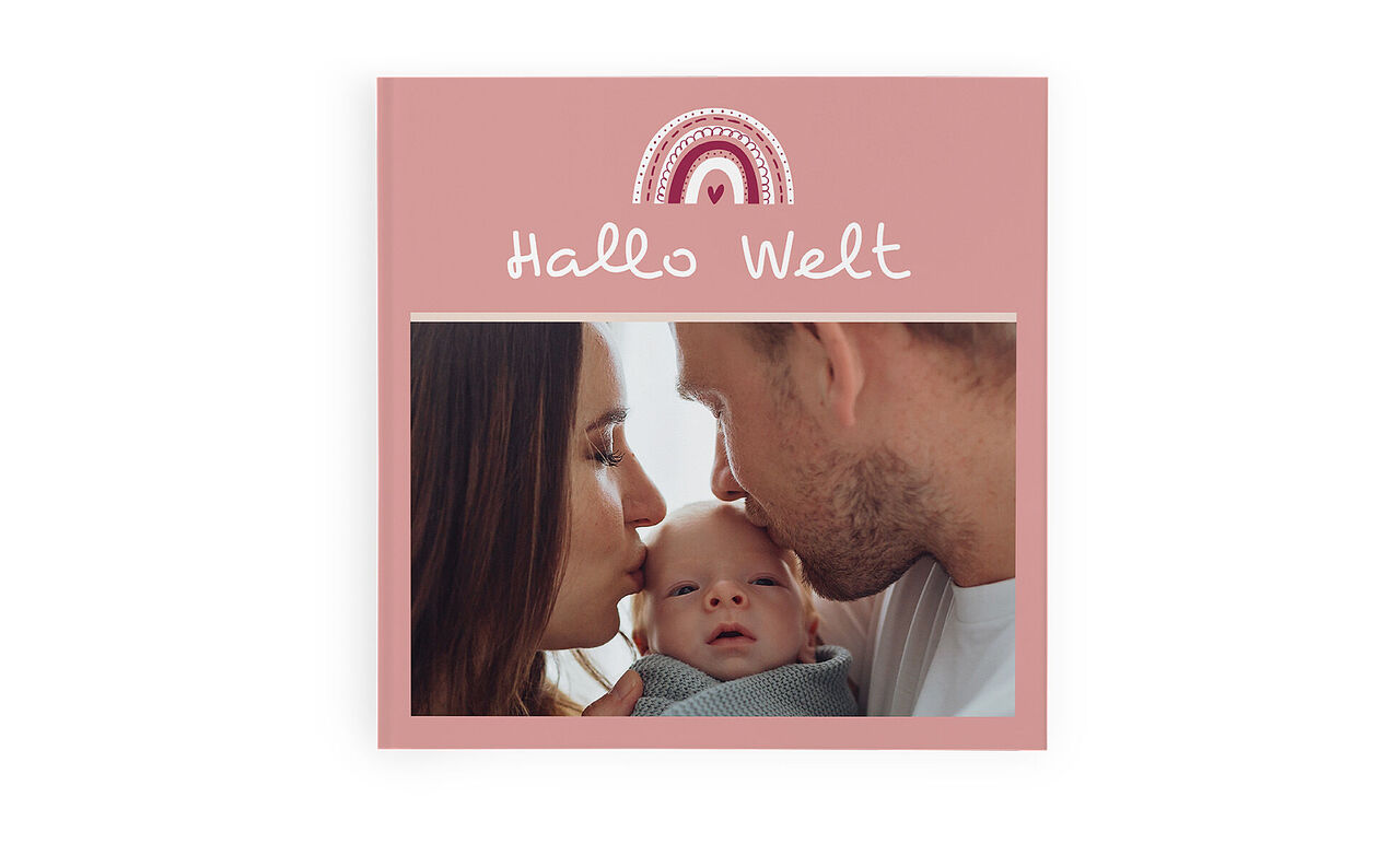 CEWE FOTOBUCH mit rosa Cover und Foto von Eltern, die ihr Neugeborenes anschauen