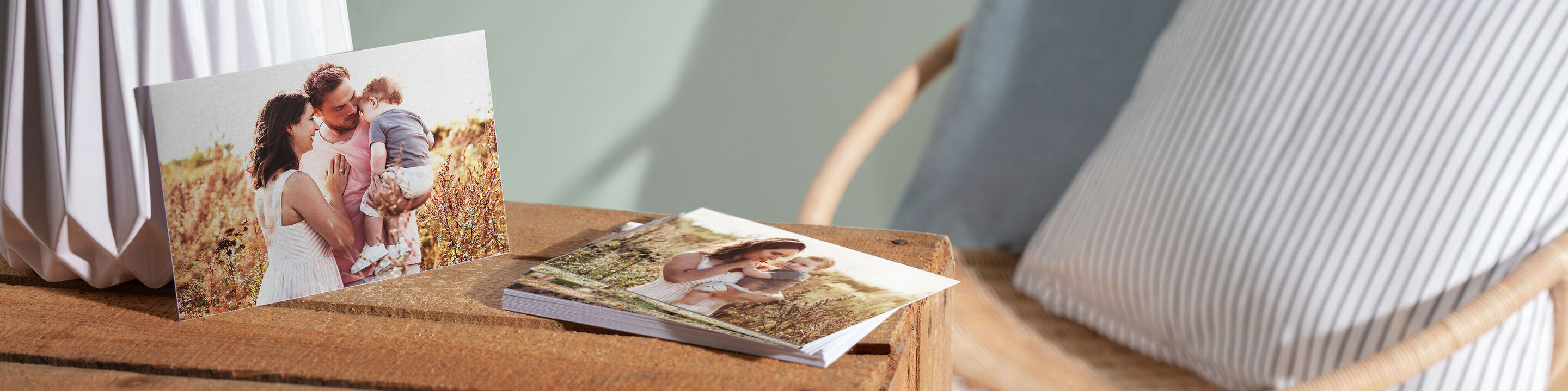 Zwei CEWE Fotobücher auf einem Tisch mit einem Bild von einer Familie.