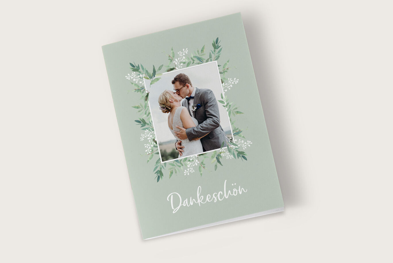 Ein CEWE Fotobuch mit floralen Elementen und einem romantischen Bildpaar auf dem Cover