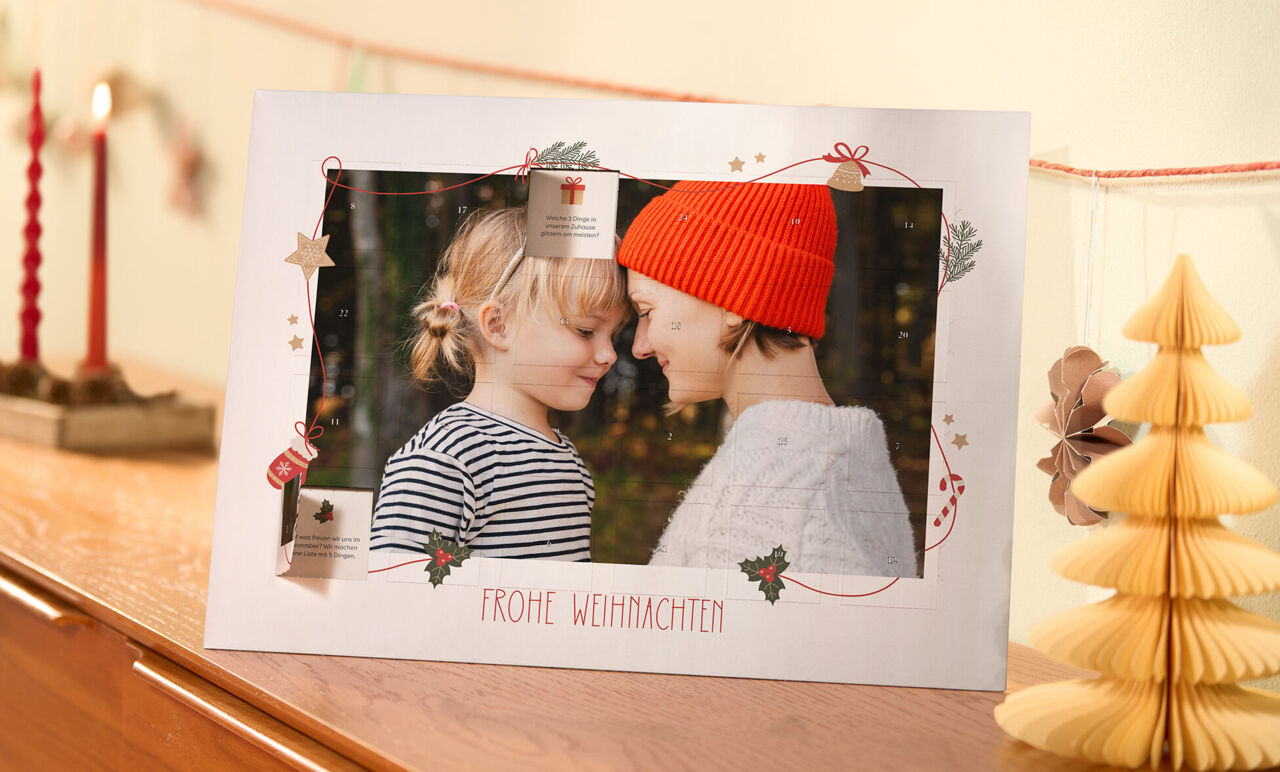 Personalisierter Adventskalender mit liebevollem Fotomotiv und festlicher Weihnachtsdekoration auf einer Kommode.