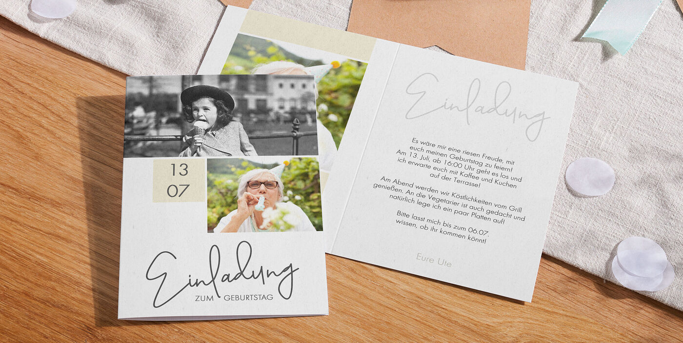 Offene CEWE Grußkarten als Einladung zum Geburtstag mit Datum, zwei Fotos und liebevoll gestaltetem Text auf einem Holztisch