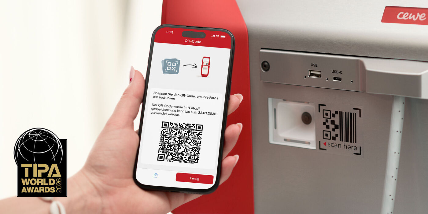 Eine Hand hält ein Smartphone, das einen QR-Code zum Ausdrucken zeigt.