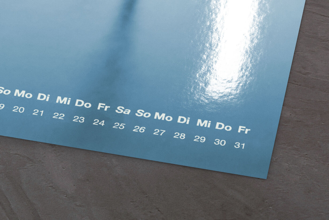 Detailaufnahme eines Kalenders mit Fotopapier in Glänzend, zeigt Wochentage und Datumszahlen auf einem edlen Hintergrund
