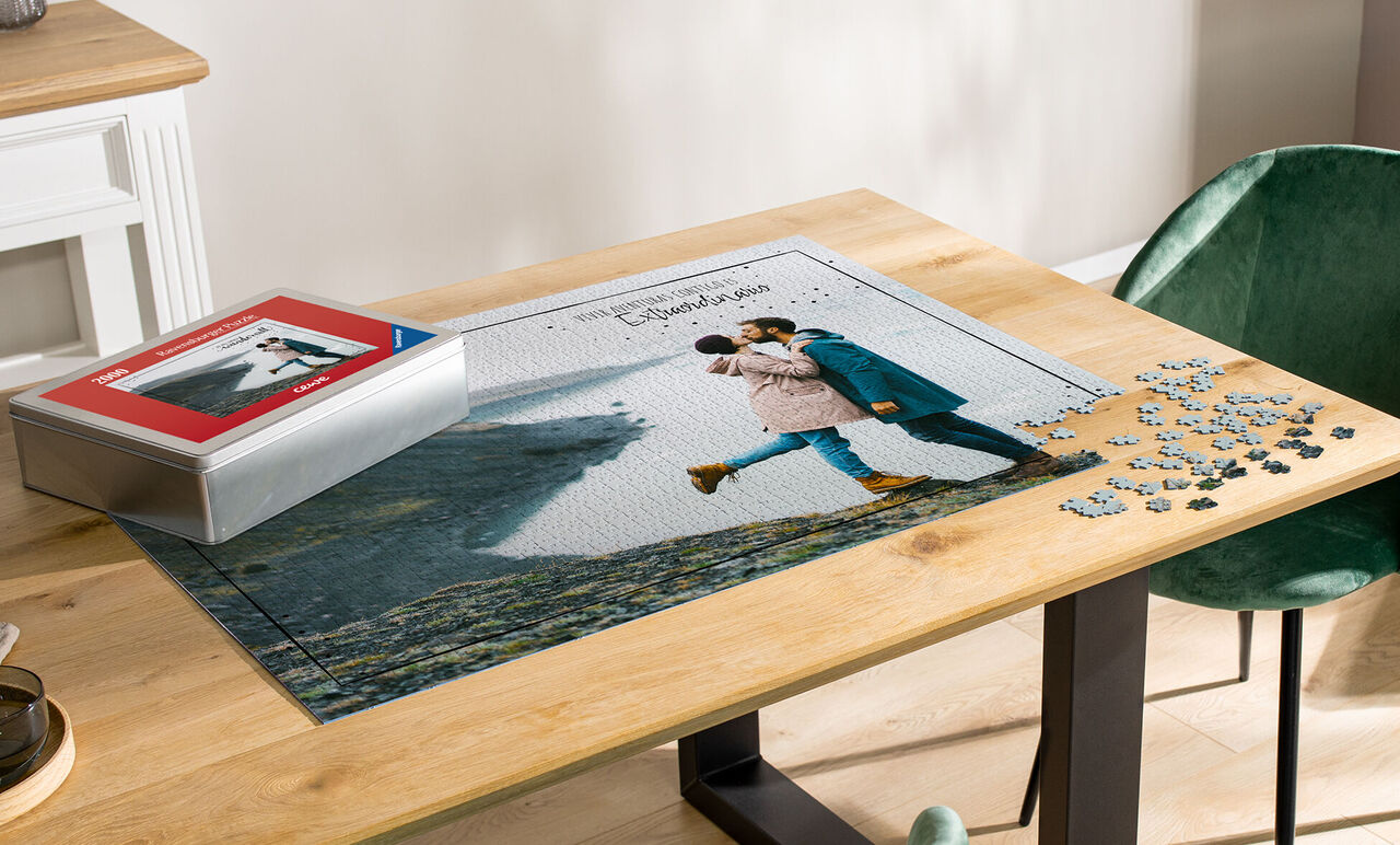 Pärchen umarmt sich während des Puzzelns auf einem Tisch