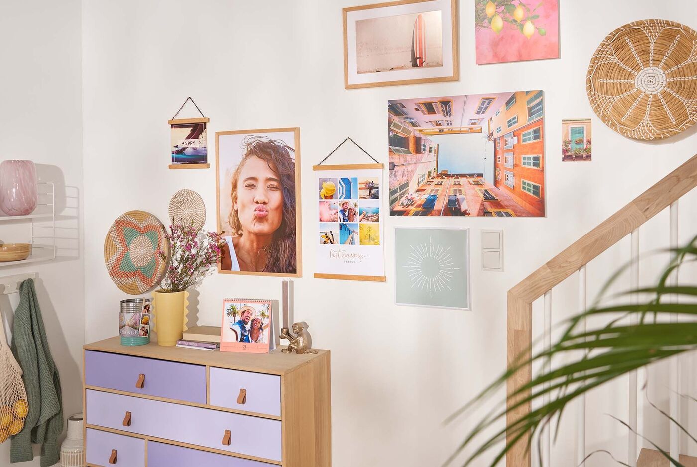 Ein stilvolles Wohnzimmer mit einer Galerie aus Bilderrahmen an der Wand und einer Kommode mit lila Schubladen