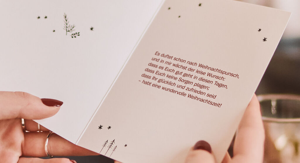 Innenseite einer Weihnachtskarte mit festlichem Text und kleinen dekorativen Elementen