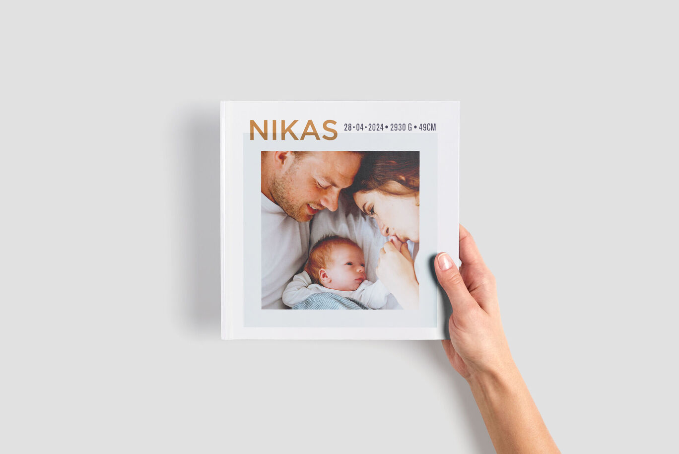 Ein liebevoll gestaltetes Fotobuch mit dem Namen "NIKAS" und zwei Fotos auf dem Cover. Das Fotobuch zeigt die Freude über den neuen Lebensabschnitt.