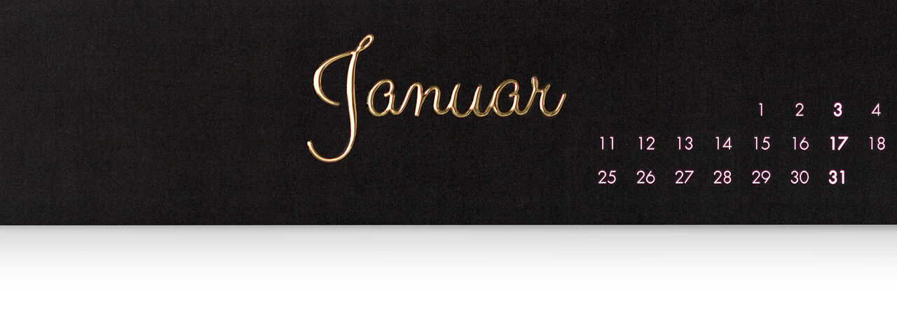 Der Kalender zeigt den Monat Januar mit einer eleganten Schrift in Gold auf schwarzem Hintergrund und kleinen Datenangaben in Rosa.