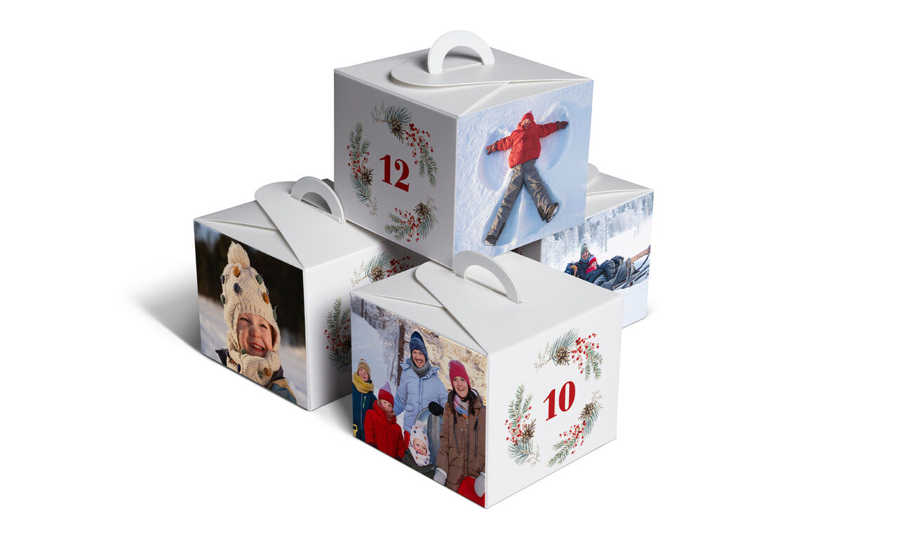 CEWE Adventskalender Geschenkboxen gestapelt mit Winterbildern und roten Zahlen 10 und 12