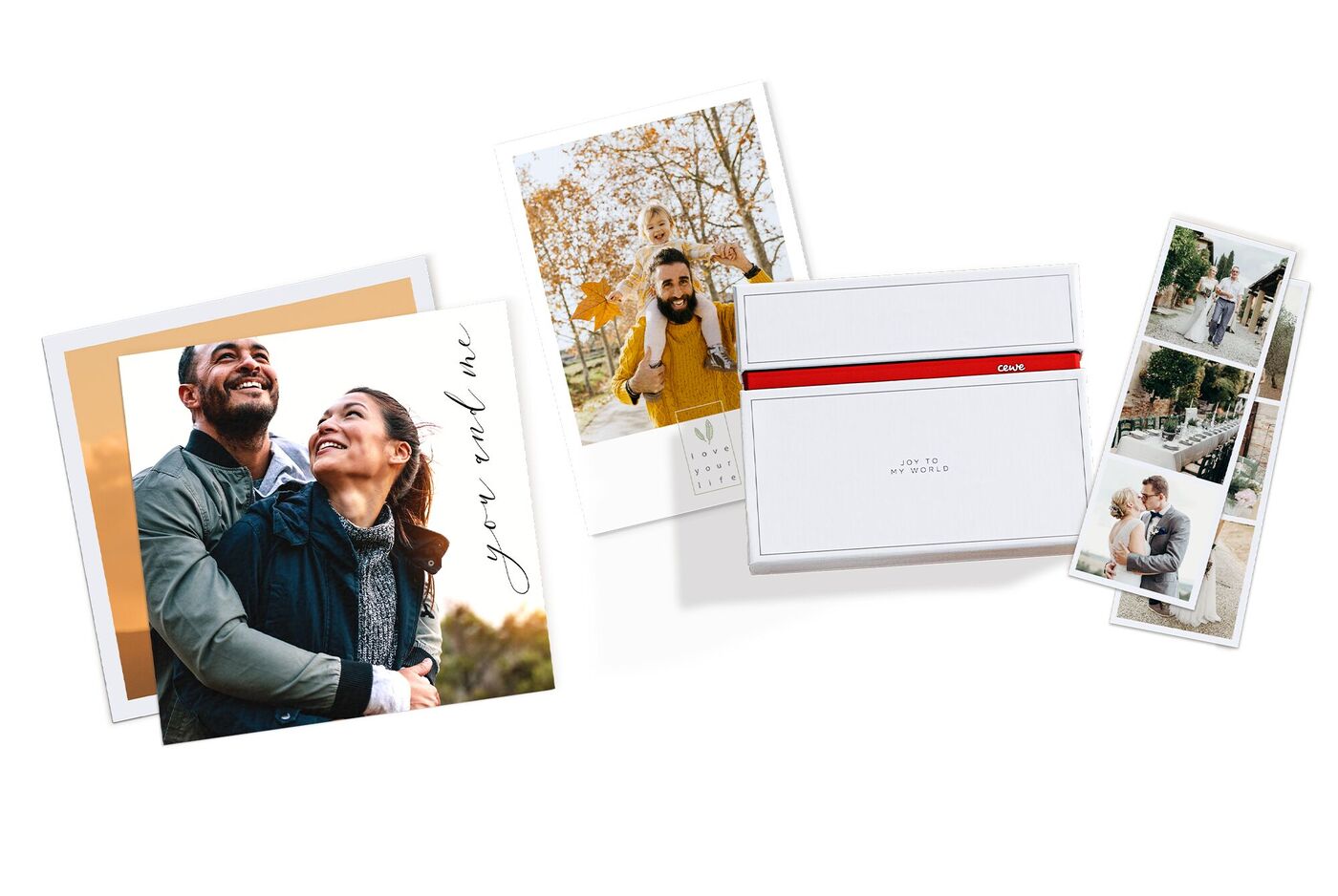 Zwei persönliche Fotokarten und ein CEWE Fotobuch stehen auf einem weißen Tisch. Die Karten zeigen liebevolle Erinnerungen im Freien.