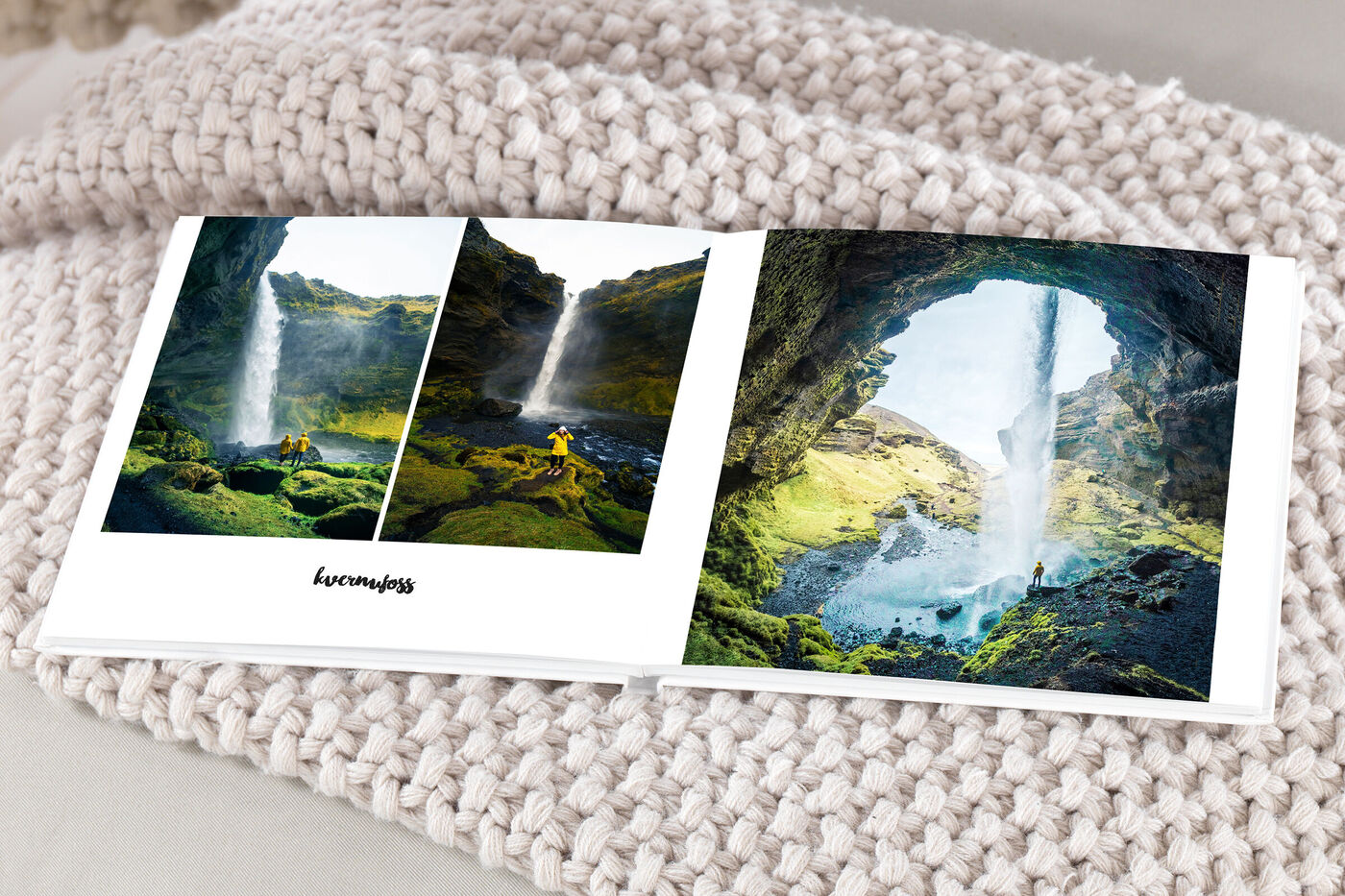Ein CEWE Fotobuch mit Bildern von einem Wasserfall in einer grünen Landschaft. Das Fotobuch liegt auf einem weichen, hellen Untergrund.