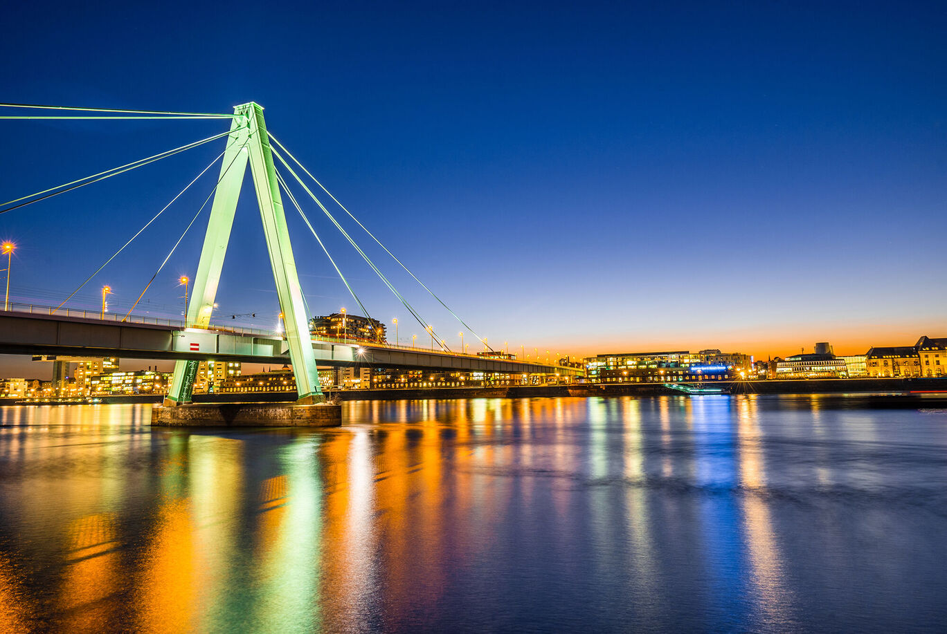 Blick auf die Lichter der Stadt am Wasser unter einer brillanten Abenddämmerung