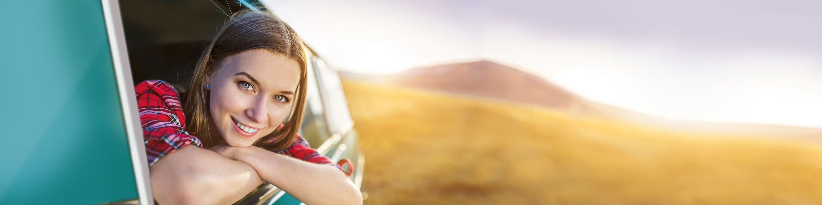Eine Person lehnt entspannt aus dem Fenster eines Fahrzeugs und genießt die schöne Landschaft.