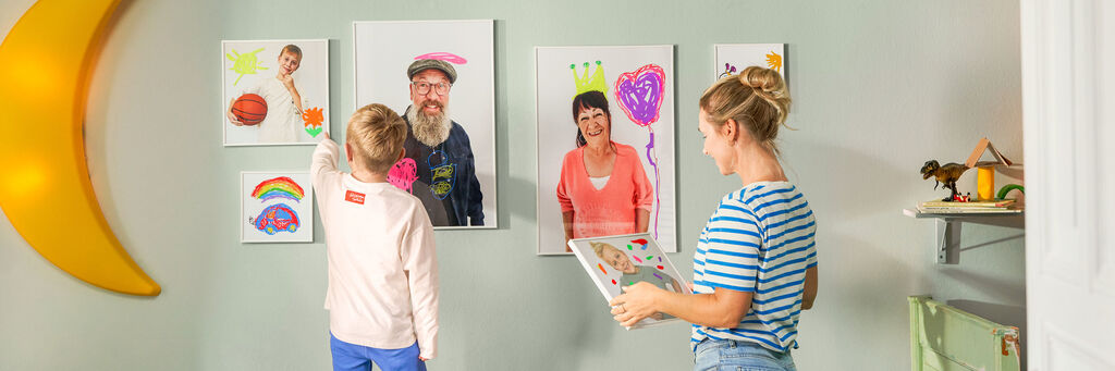 Kinder betrachten kreative, mit Farben gestaltete Bilder an der Wand