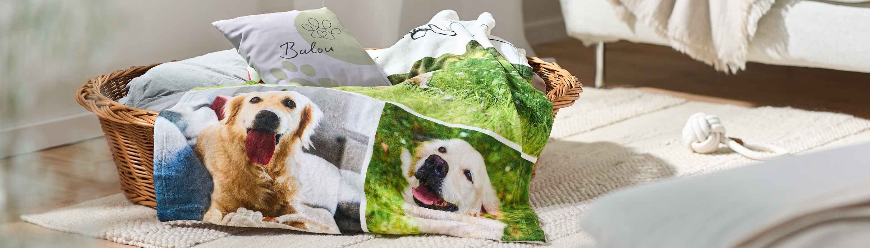 Geflochtener Hundekorb mit personalisierter Fotodecke und Kissen, bedruckt mit fröhlichen Hundebildern, im hellen Wohnzimmer.
