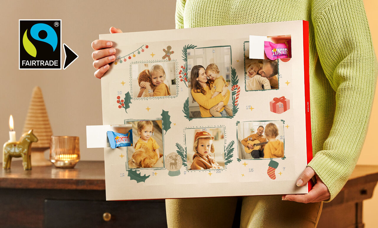 Eine Person hält einen schönen Fotokalender mit festlichen Bildern und Dekoration.