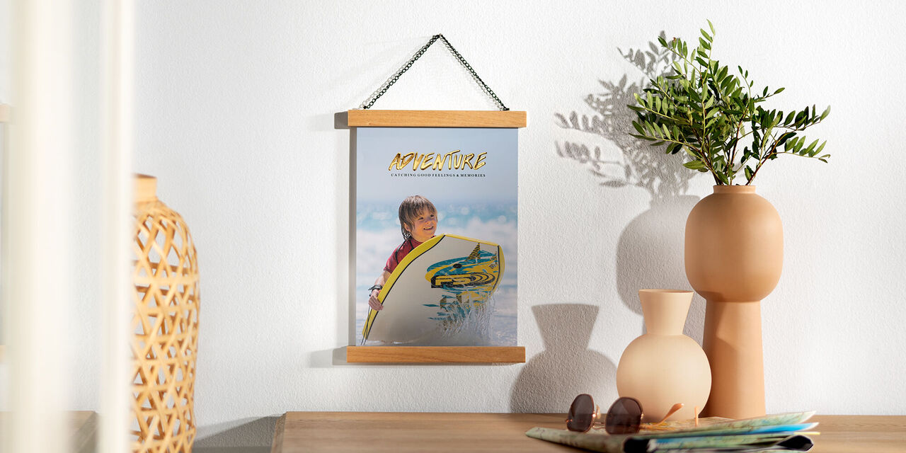 Ein schöner Wandbildrahmen mit einem Bild von einem Kind, das Spaß beim Surfen hat, aufgehängt an einer Wand.
