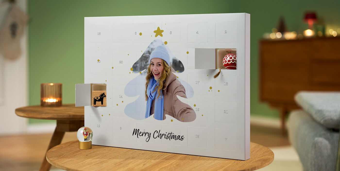 Foto-Adventskalender zum selber befüllen mit Weihnachtsbaum-Motiv und offenen Türchen auf Holztisch