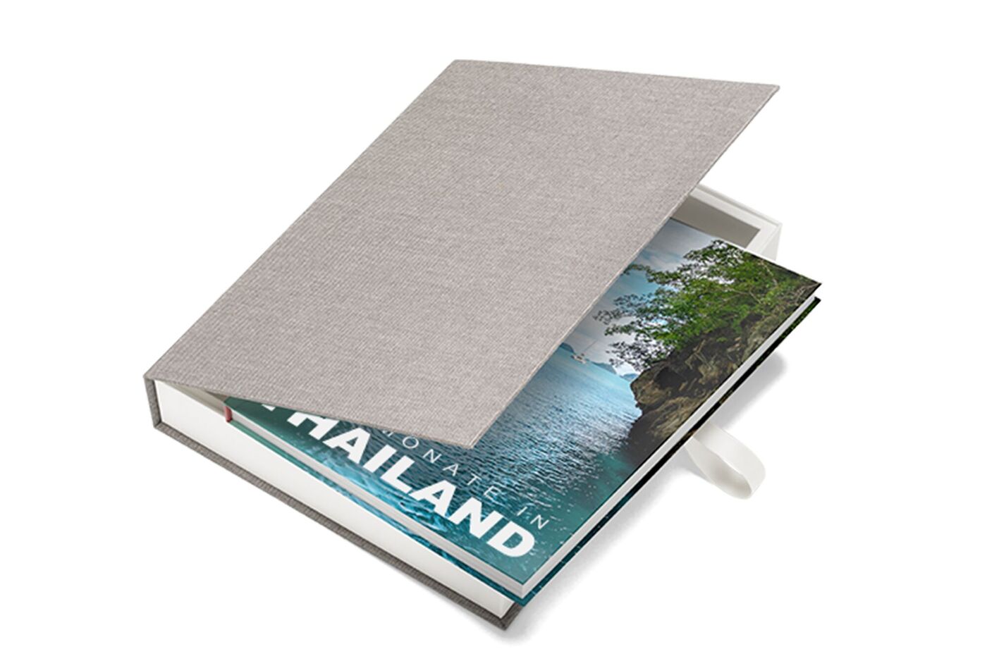 Ein CEWE FOTOBUCH mit Urlaubsbildern von Thailand in einer geöffneten Geschenkbox.