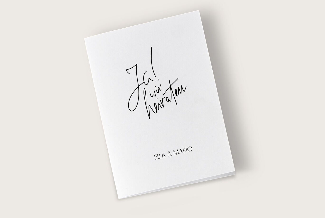 Eine elegante Hochzeitskarte mit dem aufgedruckten Text 'Ja! Wir heiraten' und den Namen 'Ella & Mario'.