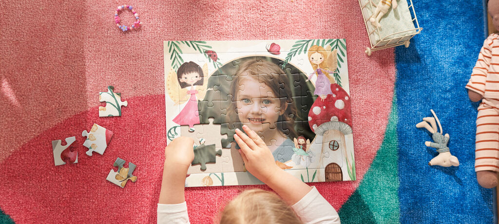 Ein Kind setzt an einem bunten Puzzle, um eine schöne Szene zusammenzusetzen