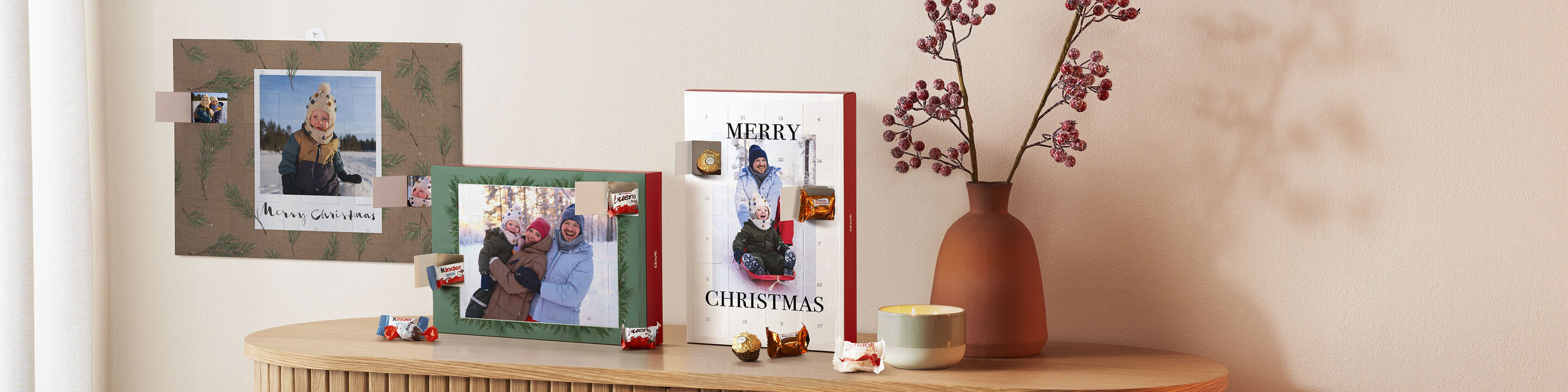 Eine festliche Weihnachtsdekoration mit einem CEWE Fotobuch und persönlichen Fotokarten auf einem Tisch.