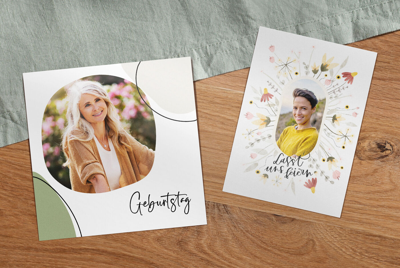 Zwei Grußkarten auf einem Holzuntergrund: Eine Karte zeigt eine Person in der Natur, die andere hat florale Designs und eine persönliche Nachricht.