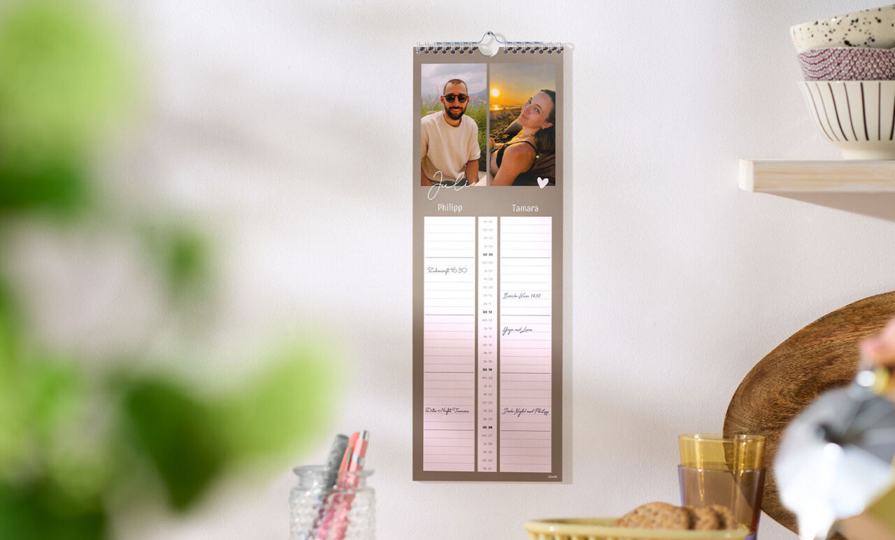CEWE Fotokalender mit zwei Familienbildern hängt in heller Küche