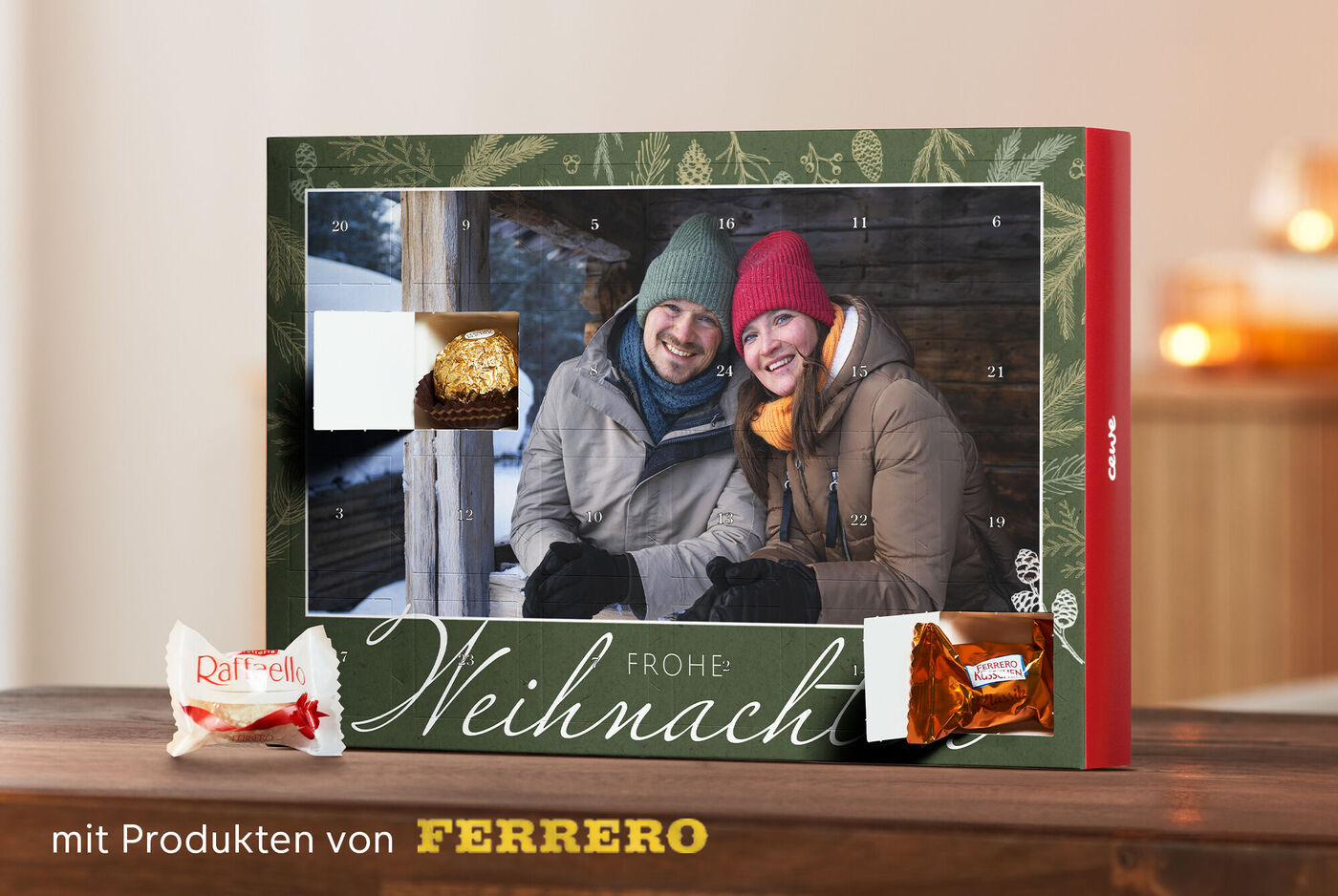 Zwei Personen in winterlicher Ausrüstung, die gemeinsam einen Adventskalender öffnen und sich freuen. Vor ihnen liegen Leckereien von Ferrero.