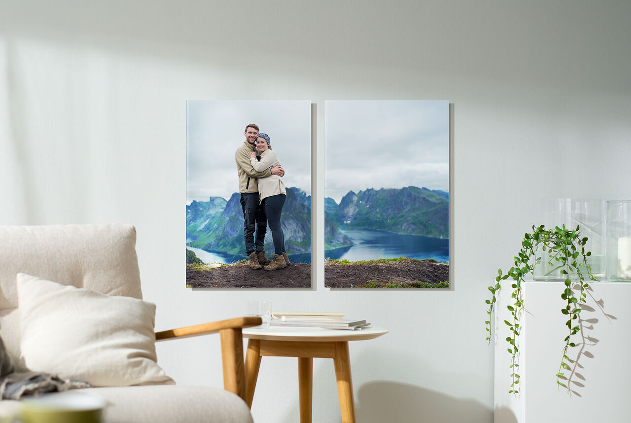 Paar umarmt sich vor einer atemberaubenden Berglandschaft, die auf zwei Bildern als Wandbild dekoriert ist