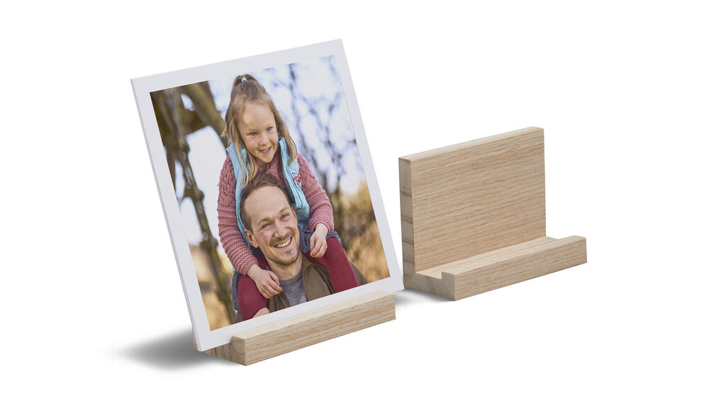 Ein gerahmtes Foto eines glücklichen Kindes auf einem Holzständer.