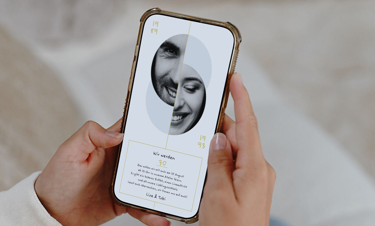 Ein Smartphone wird in den Händen gehalten, auf dem Bildschirm ist die digitale Grußkarte im Partner-Design zu sehen.