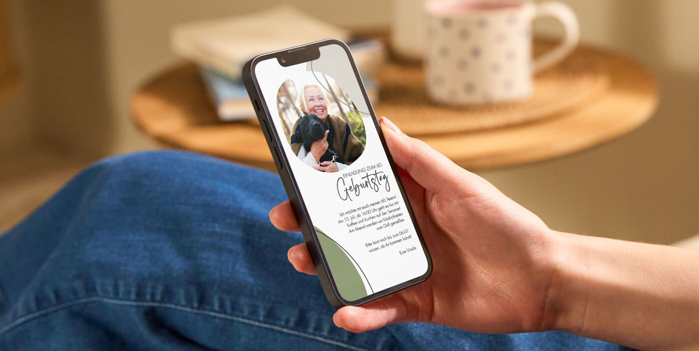 Hand hält Smartphone mit liebevoll gestalteter digitaler CEWE Einladungskarte