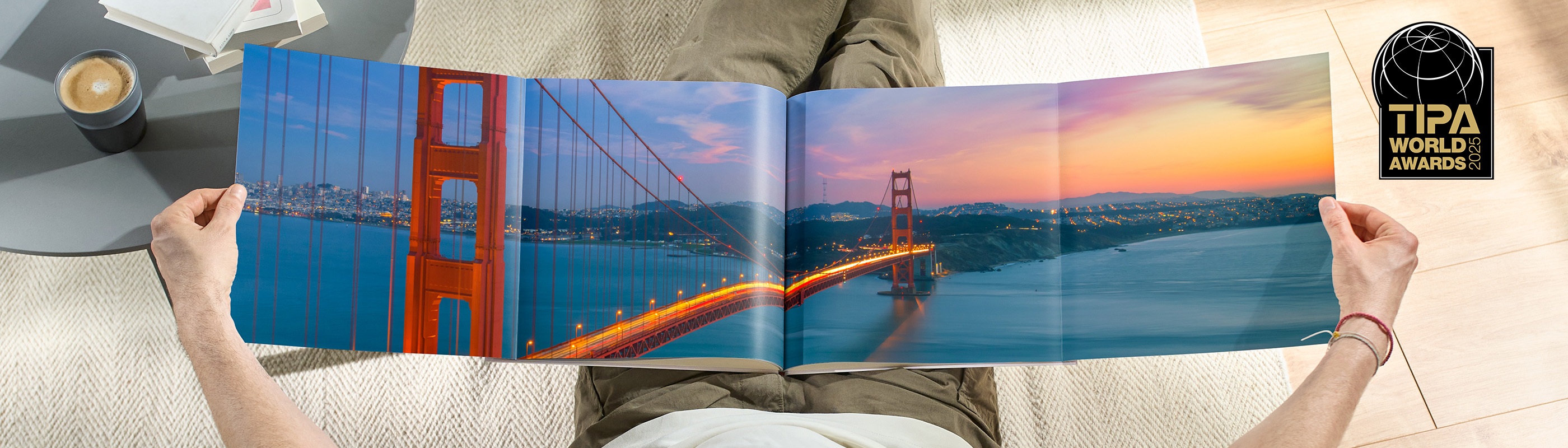 Ein Mensch hält ein großes Fotobuch mit Bildern der Golden Gate Bridge bei Sonnenuntergang in den Händen