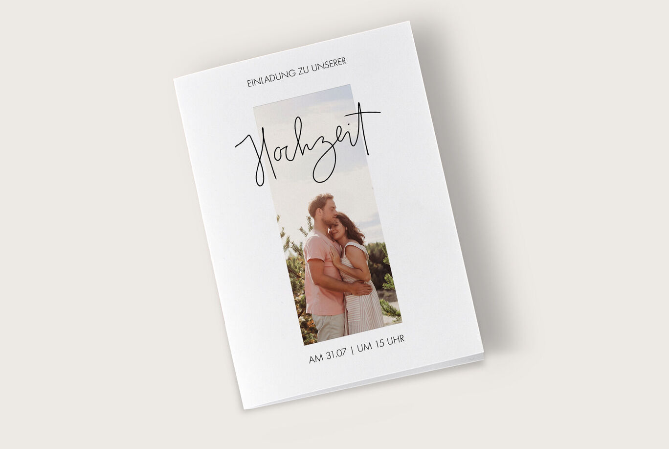 Einladungsdesign für eine Hochzeit mit romantischer Schriftart und einem Portrait-Paar im Hintergrund