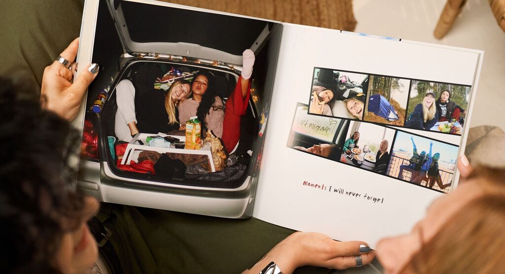 Auf einer Doppelseite im Fotobuch sieht man, wie Liss und Jule in einem Auto picknicken.