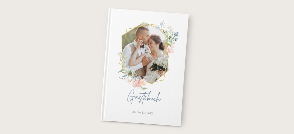 Ein liebevoll gestaltetes CEWE Fotobuch, umgeben von floralen Elementen, das besondere Erinnerungen festhält