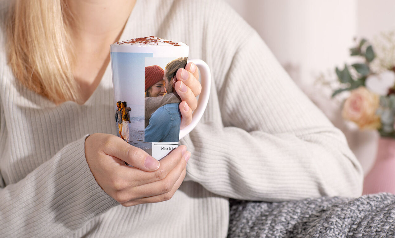 Eine Person hält eine personalisierte Tasse mit Fotos von schönen Erinnerungen.