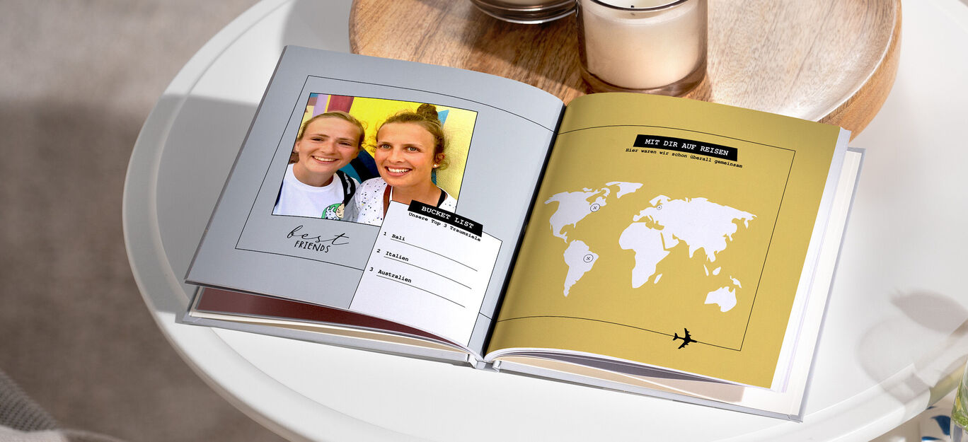 Ein offenes Fotobuch mit einer Weltkarte und einem Bild von zwei Personen