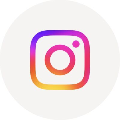 Auf einem beigen Kreis ist das Logo von Instagram, eine bunte Kamera, abgebildet.